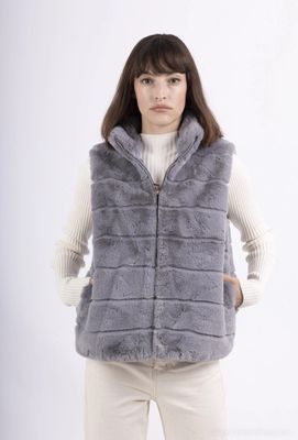 a woman wearing a grey vest and white sweater