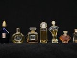 several bottles of perfume are lined up in a row on a black surface