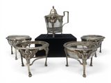 three silver plated coffee pots and four cups on a stand
