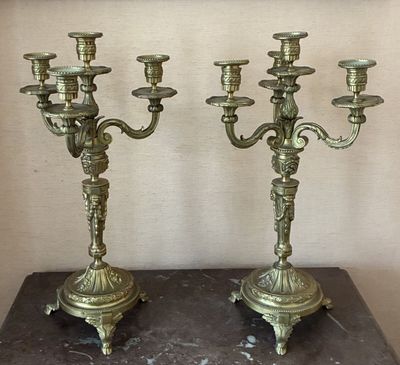 pair of antique brass candelabs on a marble table