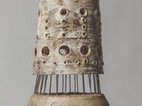 a tall vase with holes in it on a table