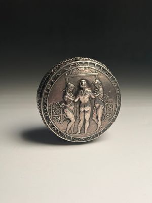 an old silver coin sitting on top of a table next to a black background