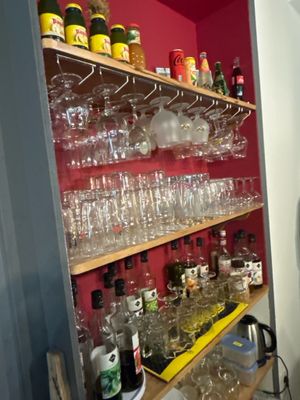many glasses and bottles on the shelves in the kitchen