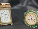 deux petites horloges posées l'une à côté de l'autre sur une table