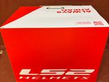 une boîte rouge avec un logo blanc posée sur une surface brune