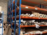 many shelves with rolls of paper on them in a warehouse
