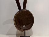 sculpture of a wooden head on a metal stand with a white background