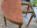 a wooden table with a glass top on a tiled floor