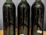 three bottles of wine sitting on top of a wooden table