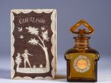 a small bottle of perfume next to a small box