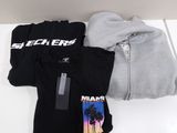 three t - shirts and a hoodie sitting on a table