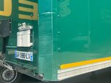 a green and yellow truck parked on the side of the road