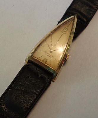 une photo d'une montre en or avec un bracelet en cuir noir