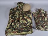 une veste de camouflage et un chapeau posés sur une surface blanche