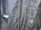 a black jacket hanging on a clothes rack in the yard