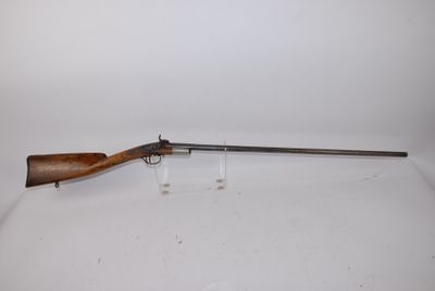 a rifle on a white surface with a white background