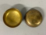 pair of antique brass buttons on a white surface