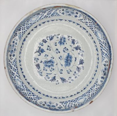 assiette bleue et blanche ornée d'un motif floral sur fond blanc