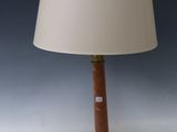 une lampe posée sur une table blanche, surmontée d'un abat-jour beige