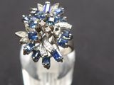 a close up of a ring with blue and white stones
