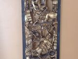 une photo d'une décoration murale en métal sur laquelle figure une horloge
