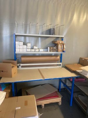 une pièce remplie de cartons et une table sur laquelle se trouve un rouleau de papier