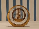 a gold clock sitting on a table with a blue and white striped wall behind it