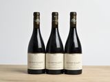 trois bouteilles de vin posées sur une table en bois