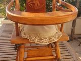 a wooden high chair that is sitting on a wooden table