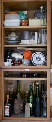 de nombreuses bouteilles et de nombreux plats sur les étagères de la cuisine