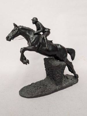 une statue représentant un homme à cheval en train de sauter par-dessus un rocher