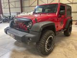 une photo d'une jeep rouge garée dans un garage