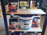 several cans of paint on a shelf in a store