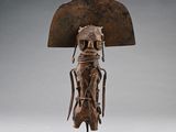 une statue en bronze représentant une femme coiffée d'un grand chapeau