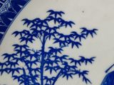 a blue and white plate with a picture of a man and a woman