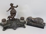 deux figurines en bronze représentant une femme et un chien, posées sur une table