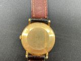 a close up of a watch on a black surface