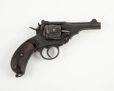 un gros plan d'un revolver posé sur une surface blanche, avec un fond blanc