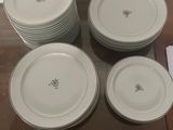 six plates sitting on a glass table with a pair of silver spoons