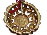 a gold ornament with a red string hanging from it