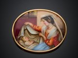 une photo ovale représentant une femme tenant un bébé contre sa poitrine