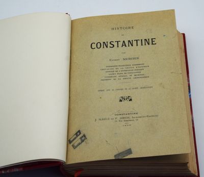 un livre ouvert posé sur une table à côté d'une tasse de café