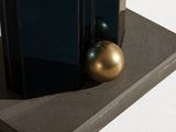 a gold ball sitting on top of a book on a stand