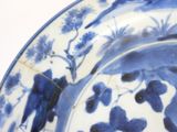 a blue and white plate with birds and flowers on it