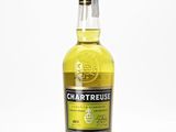 une bouteille de whisky à la Chartreuse posée sur une surface blanche