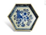une assiette bleue et blanche ornée d'un oiseau et de fleurs