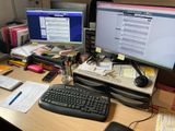 un bureau sur lequel sont posés deux écrans d'ordinateur et un clavier