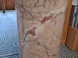 a large marble column with a white base on the floor