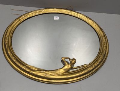 a gold mirror with a woman sitting on it
