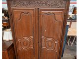 une grande armoire en bois ornée de sculptures en haut et en bas